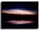 A photograph of noctilucent clouds and their reflection.